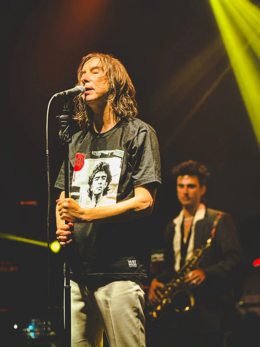 Bobby Gillespie cantando con los ojos cerrados junto a un saxofonista, foto de Maru di Rago