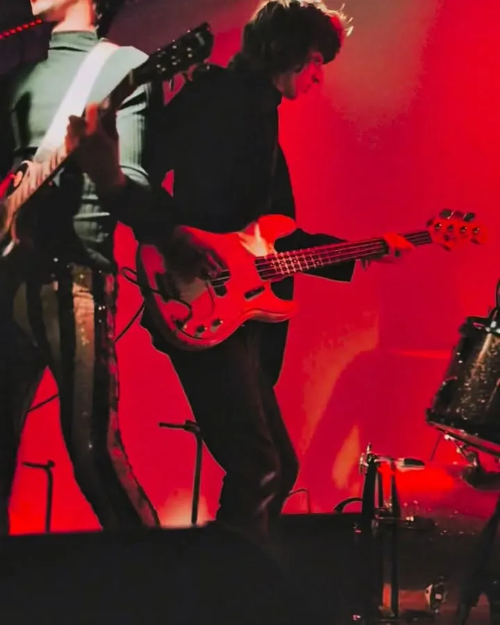 Dos músicos bajo las luces rojas del escenario